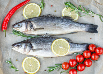 Fresh fish with spices and herbs on table in kitchen. Fresh sea bass.