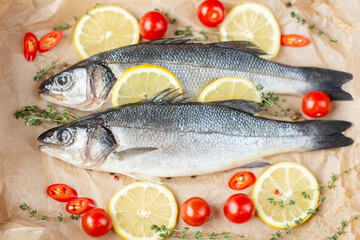 Fresh fish with spices and herbs on table in kitchen. Fresh sea bass.