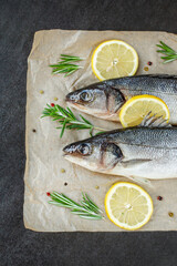 Fresh fish with spices and herbs on table in kitchen. Fresh sea bass.