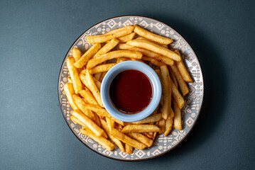 Homemade french fries with ketchup on a gray background