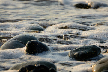 Sea waves at sunset. Sun glare in the waves.