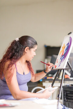 Painting artwork leisure at home. Enjoy weekend hobby. South american venezuelan mid woman close-up
