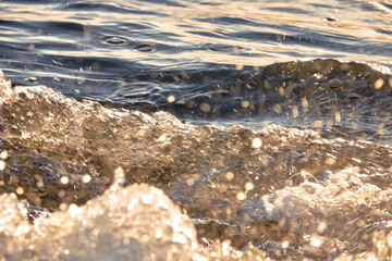 Sea waves at sunset. Sun glare in the waves.