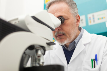 Senior scientist using a microscope in his laboratory
