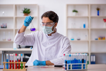 Young male chemist working at the lab