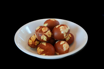 Decorated Easter egg close up on a white plate