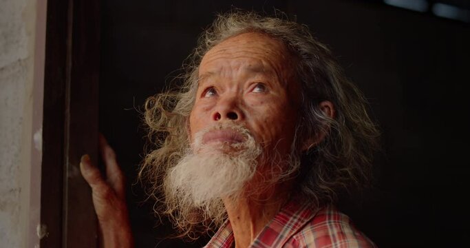 The Asian male farmer who is a poor elderly native looked up at the sky as though something had happened. Used in humanity, documentary, lonely person, environment, concepts, or movies.