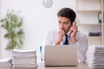 Young male employee and too much work in the office