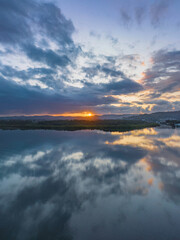 Sunrise waterscape with rain clouds and reflections