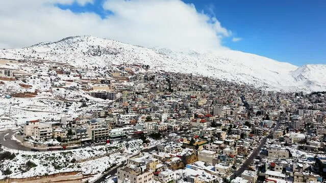 Hermon mountain and Majdal Shams houses covered with snow, Drone view