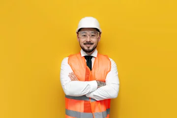 Fotobehang asian builder engineer in uniform on yellow isolated background, male korean man in hard hat and work vest © Богдан Маліцький