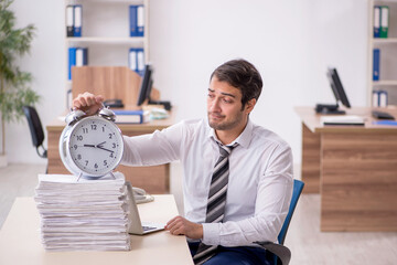 Young male employee in time management concept