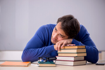 Young male student preparing for exams in the classroom