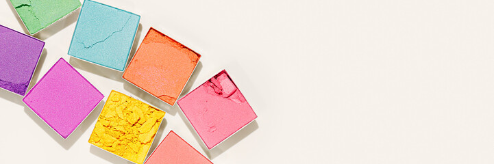 Set colors swatches powder eyes, close up cosmetic texture product for makeup on beige background, wide banner. Colorful eyeshadow palette, beauty branding, pastel color pattern, copy space