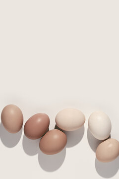 Easter eggs beige gradient color, easter minimal trend background earth neutral colors, shadow at sunlight. Chicken eggs natural colored eggshells, holiday food Easter, aesthetic flat lay