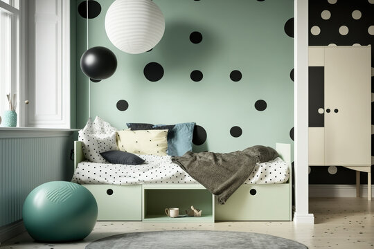 a room with polka dot wallpaper. tectile bed in olive mint with black drawers. Scandinavian style Child friendly area. Generative AI