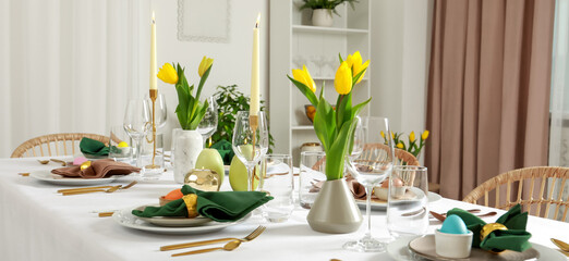 Festive Easter table setting with yellow tulips indoors, banner design