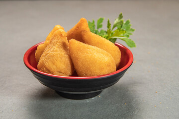 traditional fried coxinha in plate on slate background, popular brazilian snack