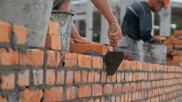 builders are building a brick wall