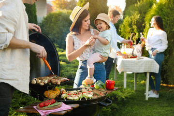 Family with friends having barbecue party outdoors