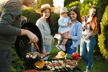 Family with friends having barbecue party outdoors