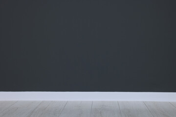 Beautiful dark grey wall and wooden floor in clean empty room