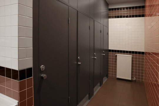 Public toilet interior with stalls and tiled walls