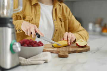 Obraz na płótnie Canvas Woman preparing ingredients for tasty smoothie at white marble table in kitchen, closeup