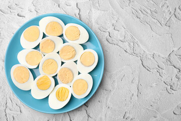 Fresh hard boiled eggs on light grey textured table, top view. Space for text
