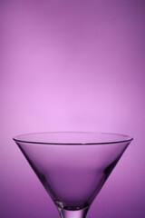 Elegant empty martini glass on purple background, closeup. Space for text