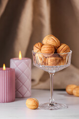 Fototapeta na wymiar Delicious nut shaped cookies and burning candles on white table