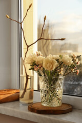 Beautiful spring flowers in vase on windowsill indoors
