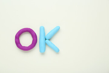 Word Ok made of colorful plasticine on white background, top view. Space for text