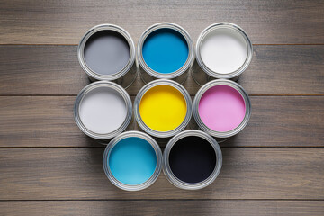Cans of different paints on wooden table, flat lay