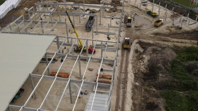 the crane installs the structure on the base of the warehouse