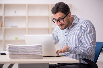 Naklejka premium Young male employee working in the office