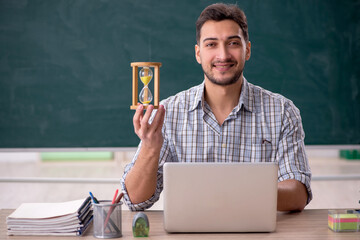 Young male teacher in time management concept