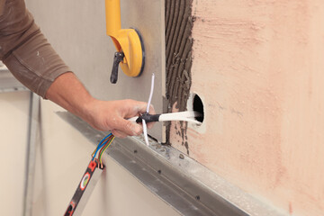 Worker installing socket in tile indoors, closeup