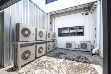 Air conditioning system on ground side of habitat. Multiple white compressor air condition...