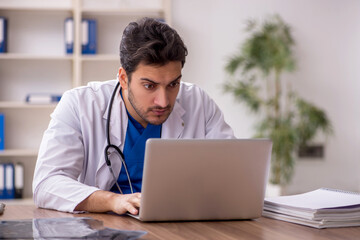 Fototapeta premium Young male doctor in telemedicine concept