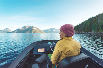 Woman Driving Motor Boat at Sunset in Coastal British Columbia in Nature Landscape Near Bute, Toba Inlet and Campbell River. Whale Watching Tourist Travel Destination, Canada - obrazy, fototapety, plakaty