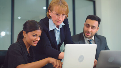 Multiethnic business team people looking to computer together at office. They have a happy expression and celebrate when the business is successful.