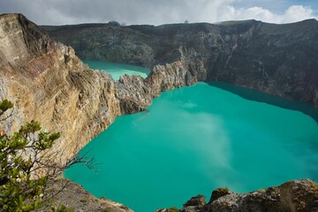 Panoramic view over the volcano Mount Kelimutu in Ende on Flores with its two sunlit turquoise crater lakes.
