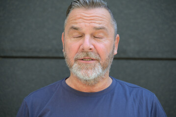 Middle aged bearded man posing with closed eyes