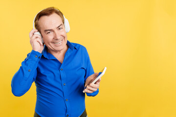 Mature man listening to music with headphones and mobile