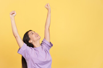 Happy caucasian woman celebrating while raising arms