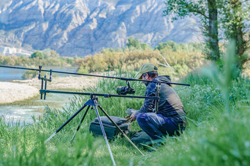 Fototapeta na wymiar male angler preparing on the river for a carpfishing trip