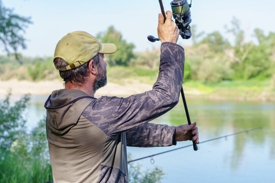 angler casting the rod into the river carpfishing session