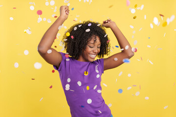 Cool Afro woman dancing and celebrating surrounded by confetti