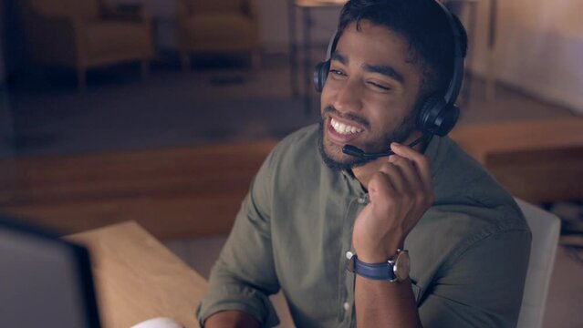 Call center, night and face of man, agent or consultant tech support, online solution or global help desk. International, virtual worker or headset of indian person consulting or talking on desktop